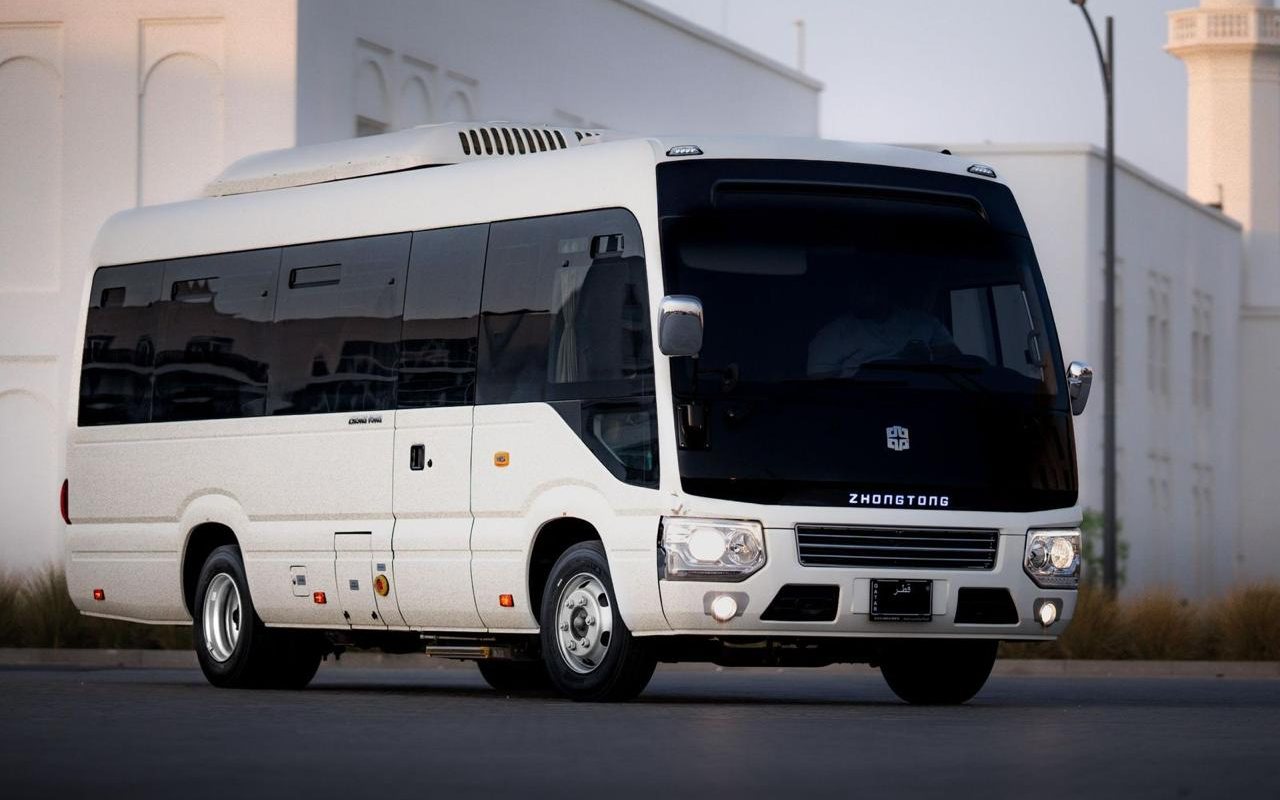 Dunescape's white Zhongtong coaster minibus on a Doha forecourt