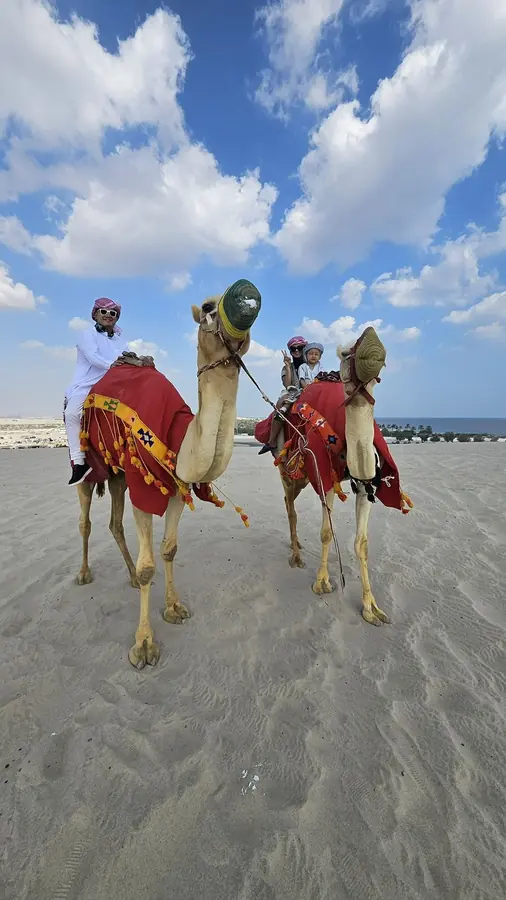Two camel riders crossing the sand at the inland sea