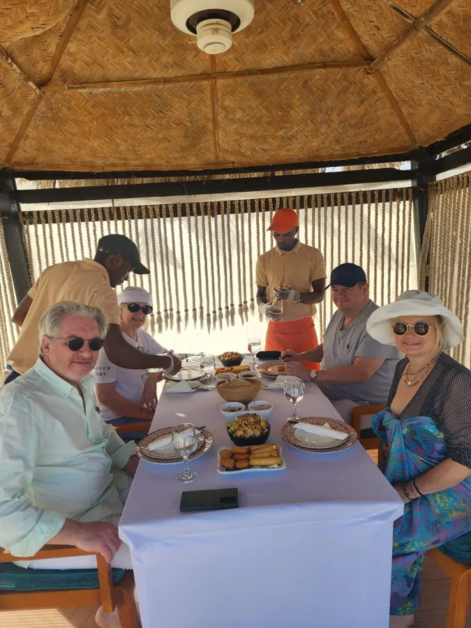 Guests sharing breakfast under the majlis canopy at our desert camp