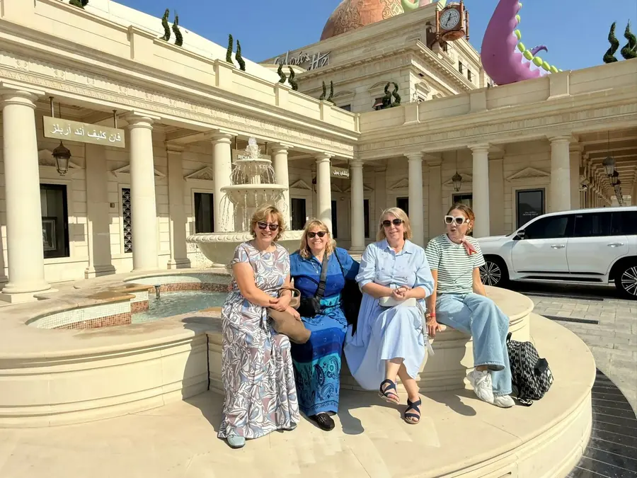 Four guests resting at a fountain during a morning city tour