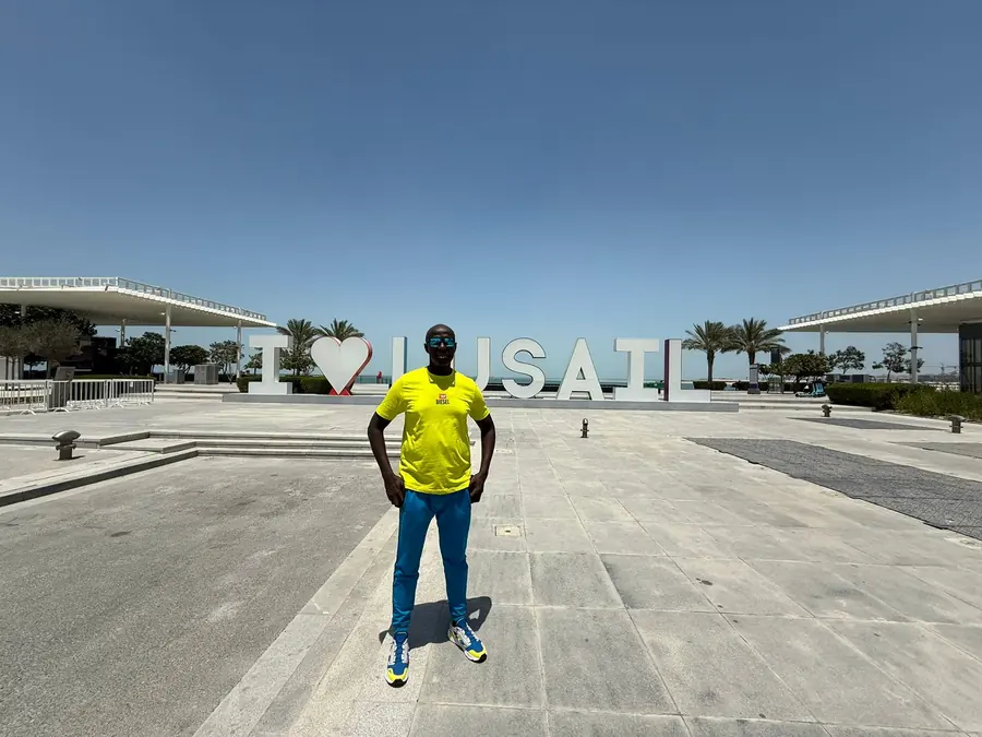 A guest at the I Love Lusail sign