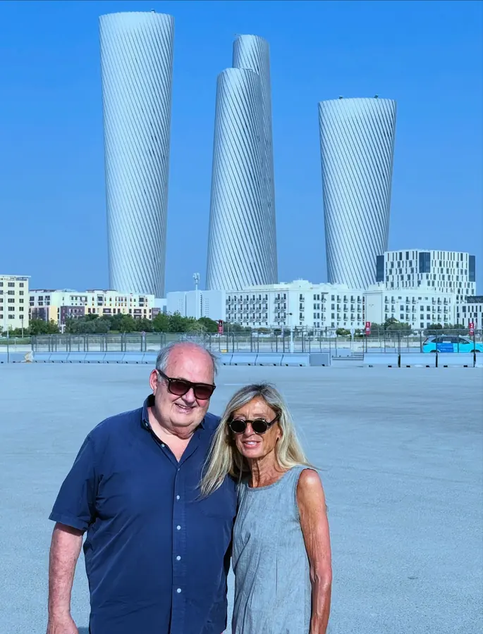 A couple standing in front of the three Lusail Towers