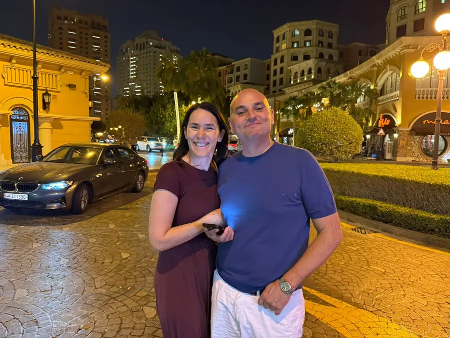 A couple in the lantern-lit lanes of Qanat Quartier after dark