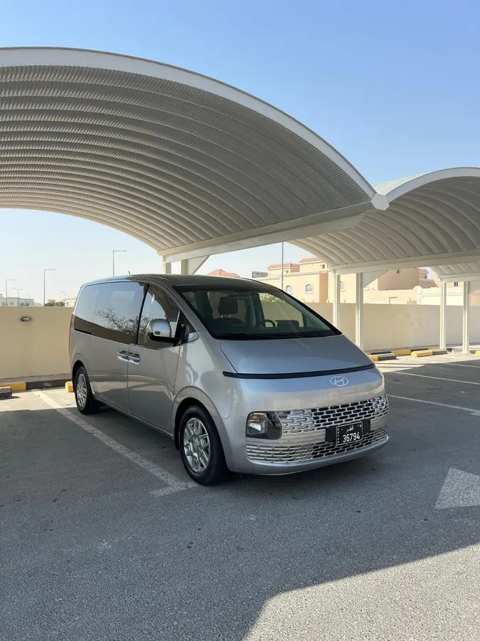 A silver Staria parked beneath a shade canopy before a transfer